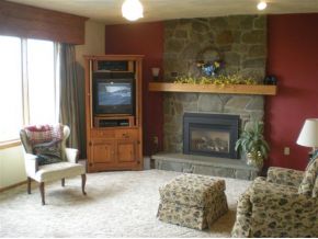 King Point Circle stone fireplace in a living room with red walls