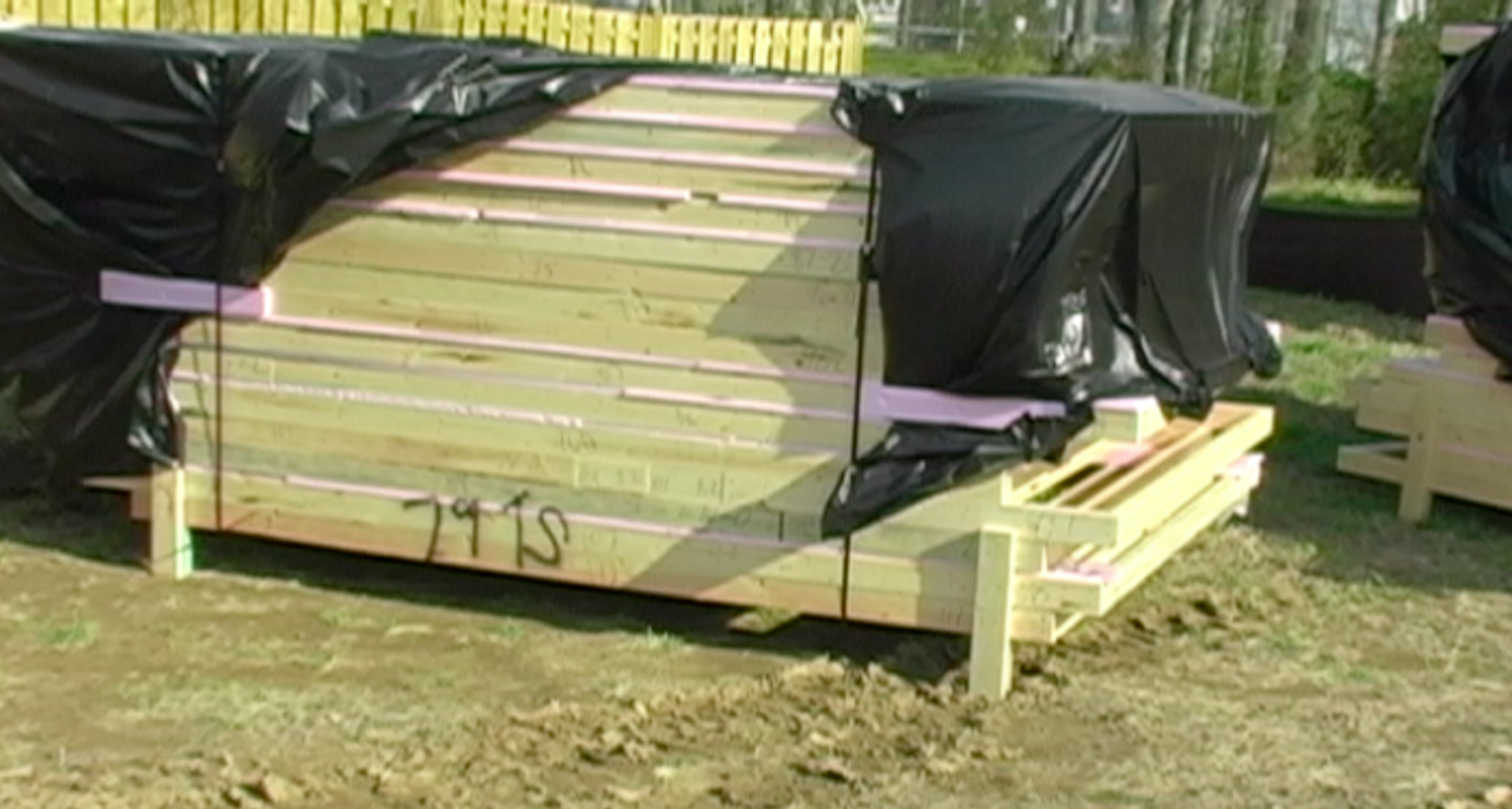 Pre-fabricated wall panels lay on home site awaiting assembly. 